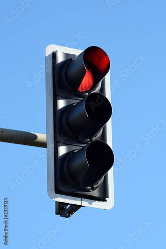 red traffic light and a blue sky. photo