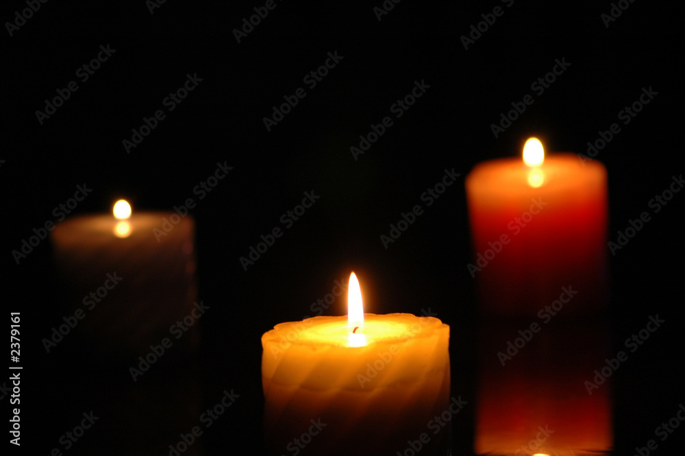 three candles in the darkness - focus on the middle one