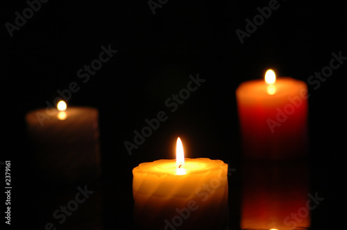 three candles in the darkness - focus on the middle one