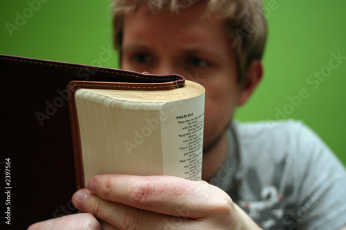 young man reading small bible