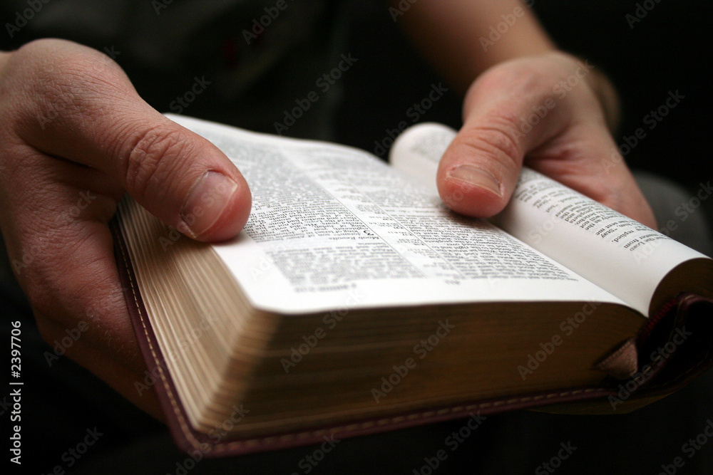 Fototapeta premium young man reading small bible
