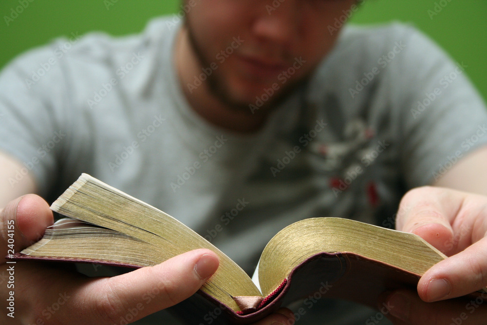 Obraz premium young man reading small bible