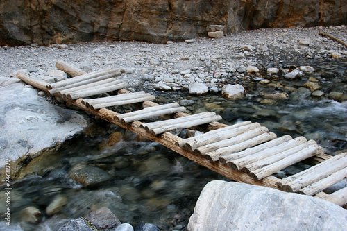 old wooden bridge over flowing stream