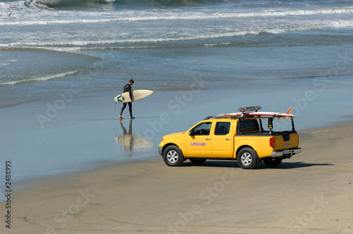 surfer walks beach