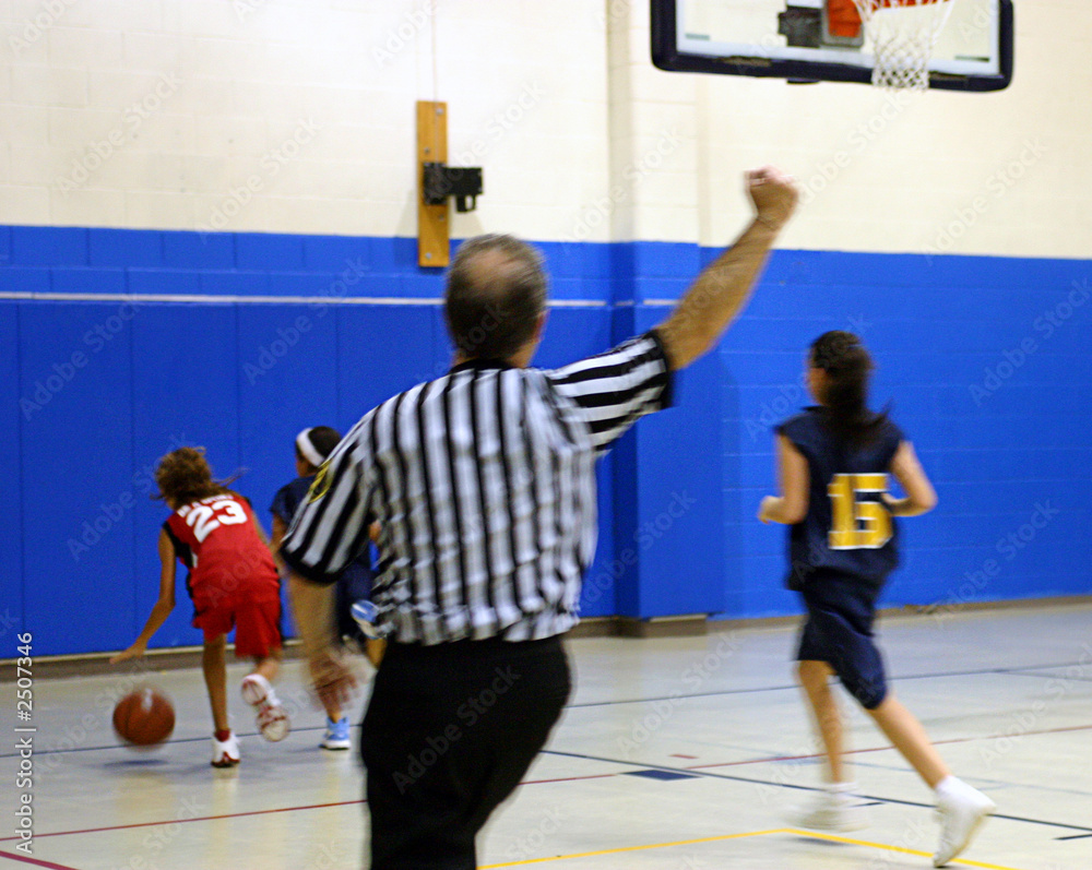 Obraz premium referee making a call at a girls basketball game