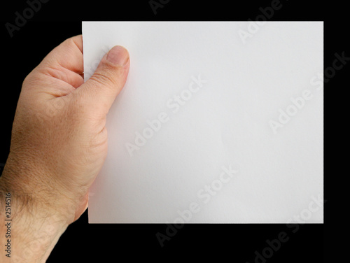 the hand holds a leaf of a paper. photo
