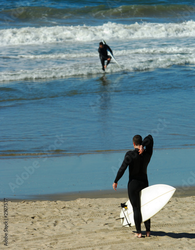 surfer adjusts wetsuit
