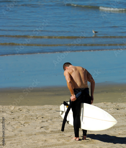surfer removes wetsuit