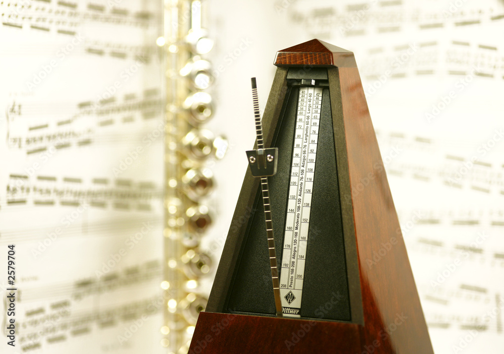 flûte et métronome devant une partition de musique Stock Photo Adobe