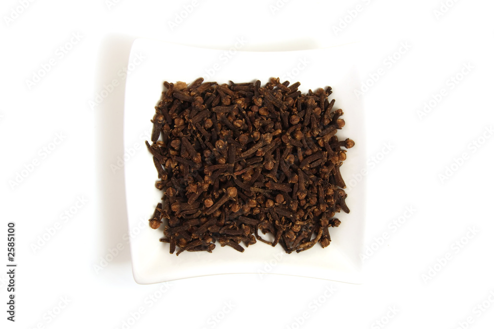 whole cloves in square white bowl isolated whole cloves in square white bowl isolated