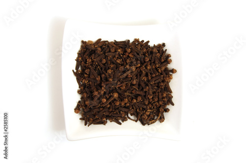 whole cloves in square white bowl isolated