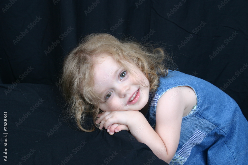 cute little girl sitting on black background. cute little girl sitting on black background.