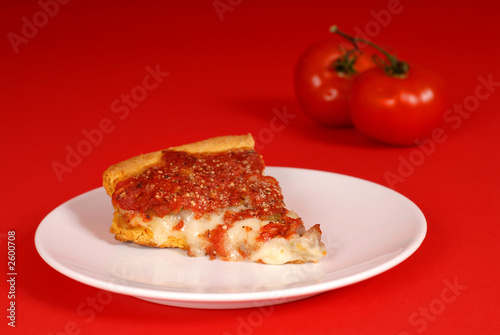 a piece of deep dish pizza with tomatoes