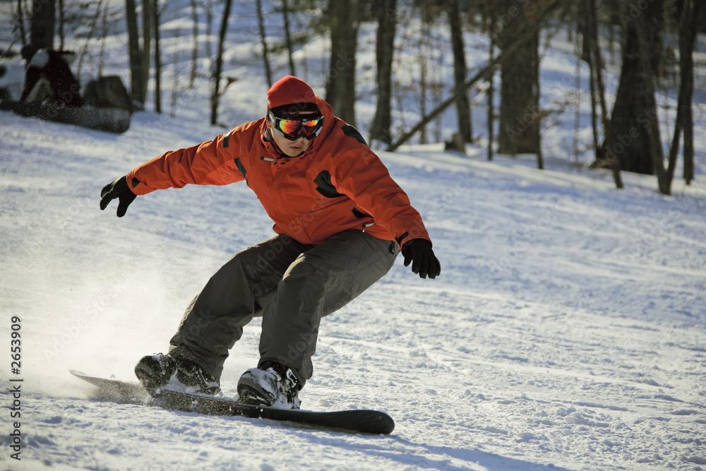 sliding snowboarder on flank of hill