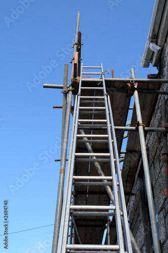 a builder’s ladder and scaffolding on a house bein