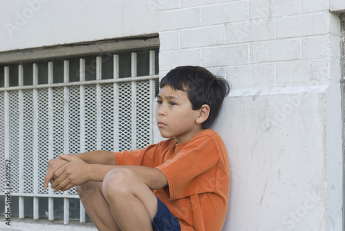 boy sitting against wall