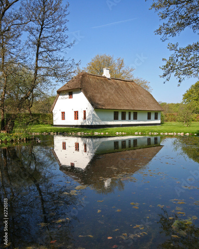 reflection of old house in pond