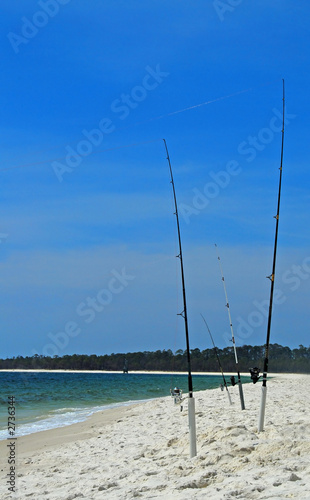 fishing poles in sand