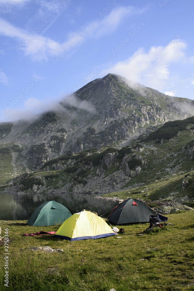 mountain landscape with tent camp and mountain lake