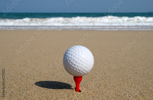 golf ball on the beach, ready to be hit in to the