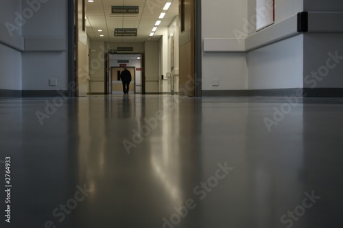 man walking along hospital corridor