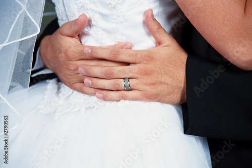 grooms hands wrapped around brides waist