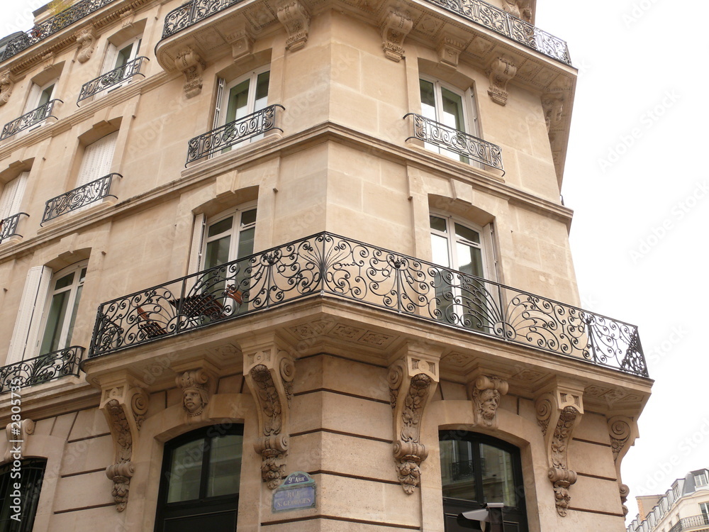 Fototapeta premium façade en coin; immeuble blanc en pierre de taille.