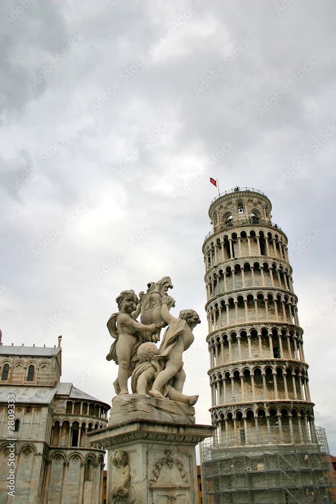 pisa tower and statue on background of the cloudy