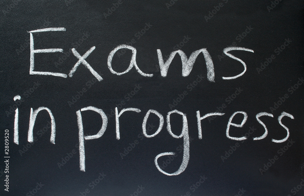 exams in progress, written on a school blackboard. exams in progress, written on a school blackboard.