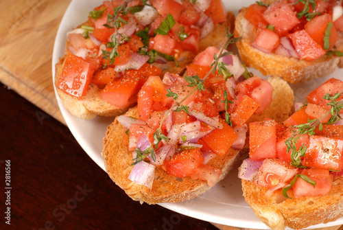 tomato and onion bruschetta with thyme on cutting board