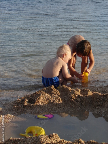 kids playing in beach sand photo