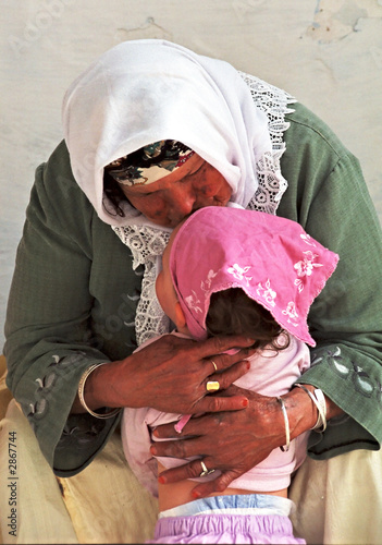 Fotografie grandmother kissing a little girl