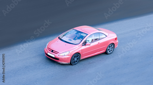 woman driving small pink coupe car fast speed