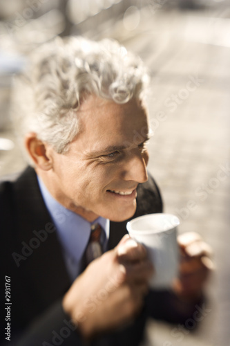 businessman drinking coffee and smiling.