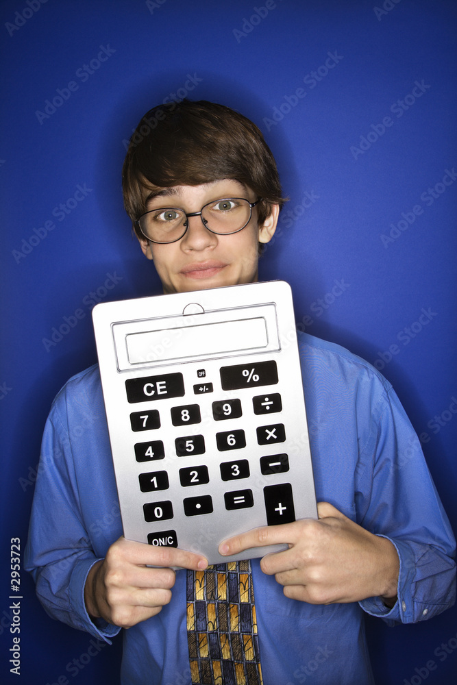 caucasian teen boy holding calculator. caucasian teen boy holding calculator.