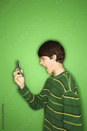 caucasian teen boy screaming at cellphone.