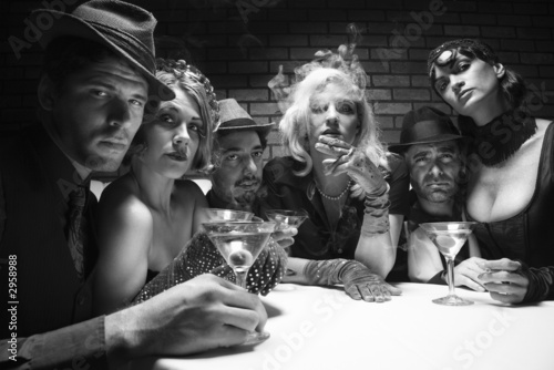 retro males and females sitting at table in lounge.