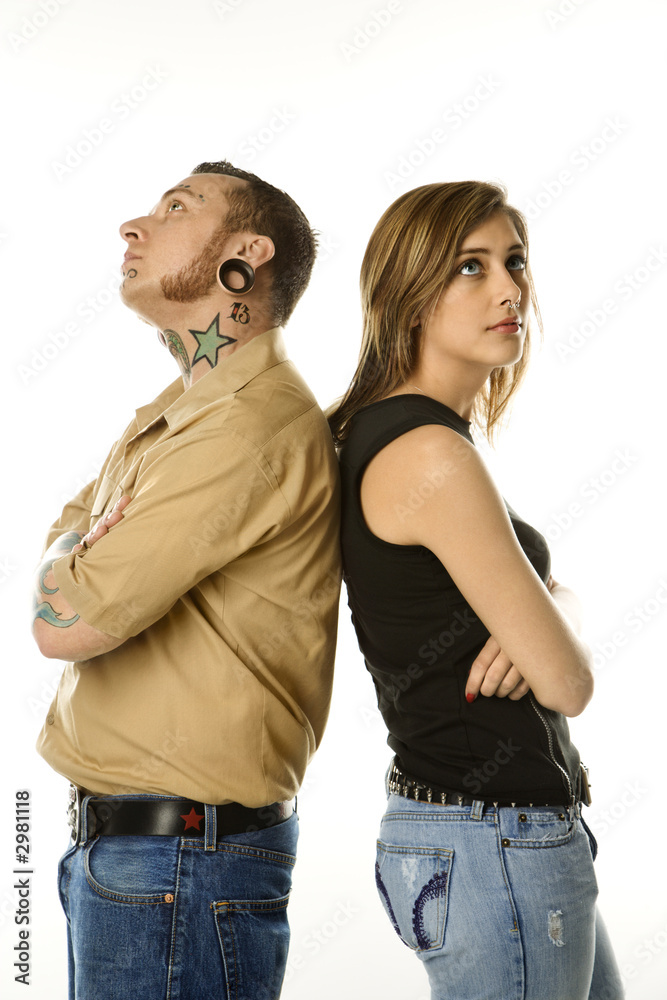 Caucasian male and teen female standing back to back. Caucasian male and teen female standing back to back.