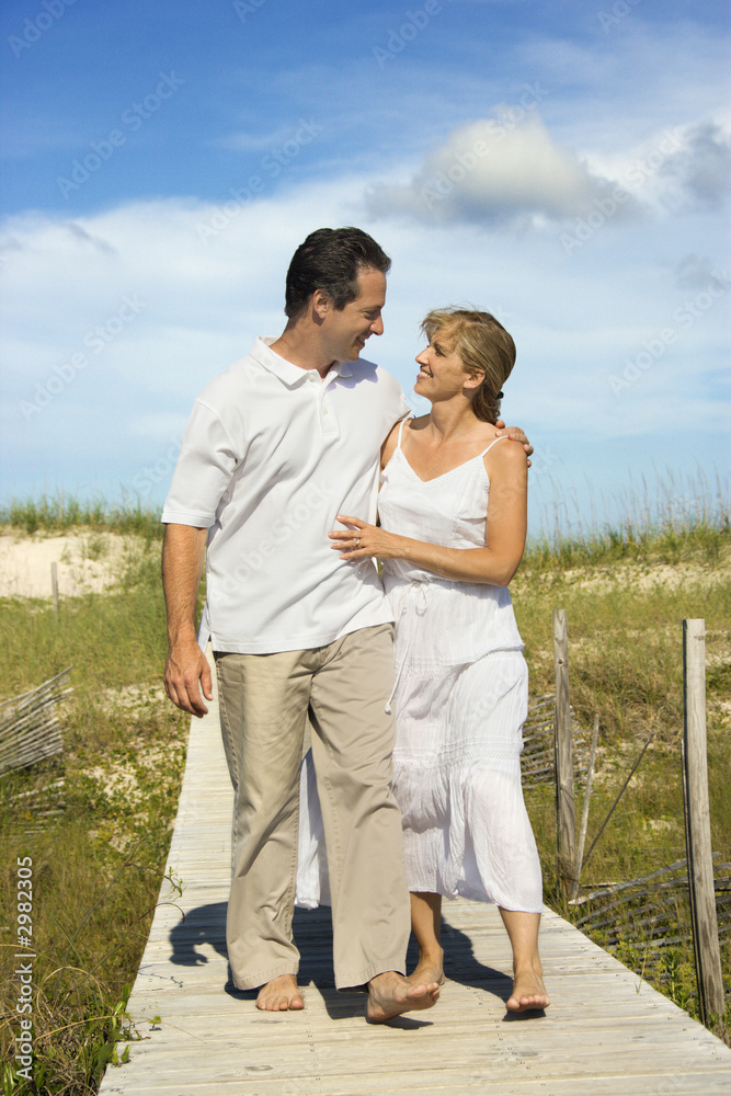Couple holding each other walking down path. Couple holding each other walking down path.