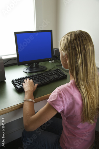 Pre-teen girl working at computer.