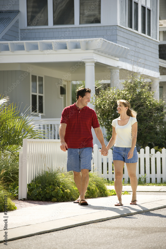 Fototapeta premium Couple walking on sidewalk.