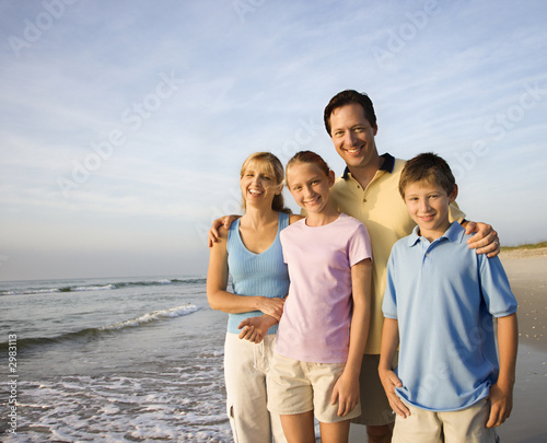 Smiling family on beach. © iofoto