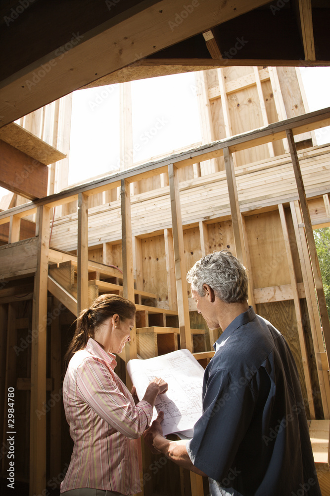 Caucasian man and woman on construction site.