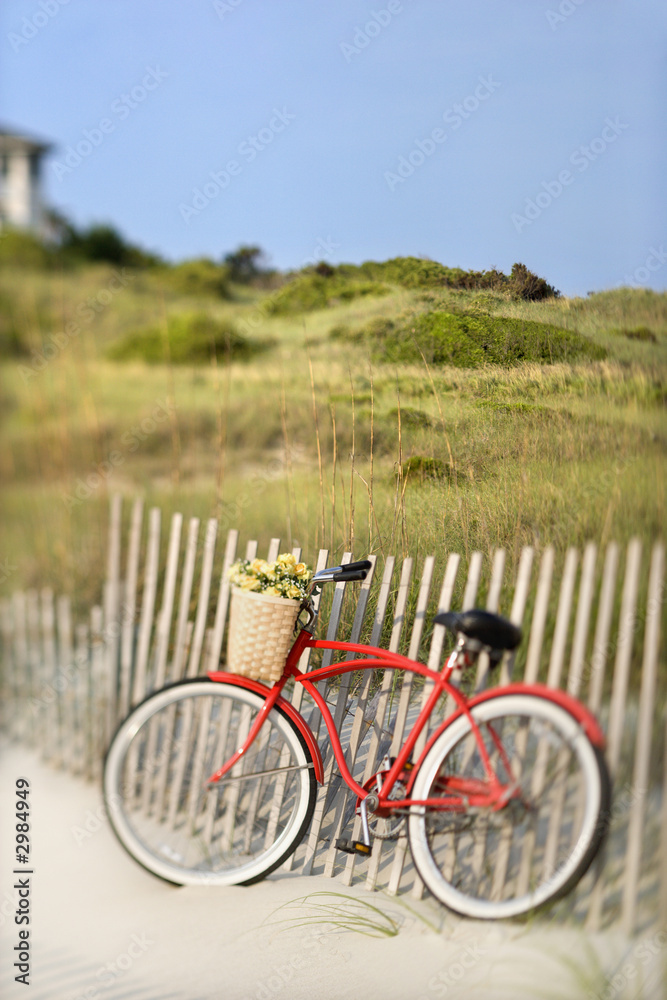 Fototapeta premium Bike leaning against fence at beach.
