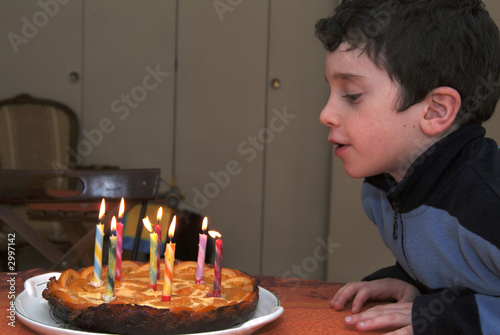 enfant soufflant sur un gateau d'anniversaire photo