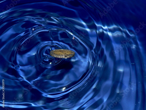 euro coin splash in blue water
