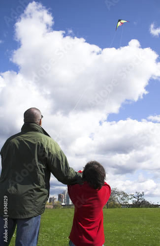 father and son flying kite together