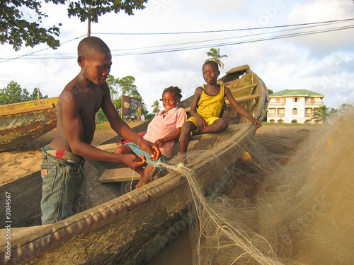 young african childrens on a typical boat coming back from fishi