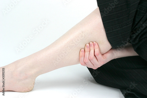 woman holding sore leg muscle