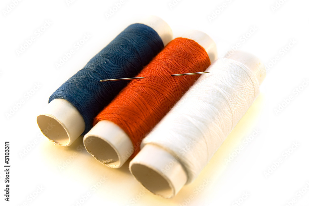 blue, red and white threads with needle blue, red and white threads with needle